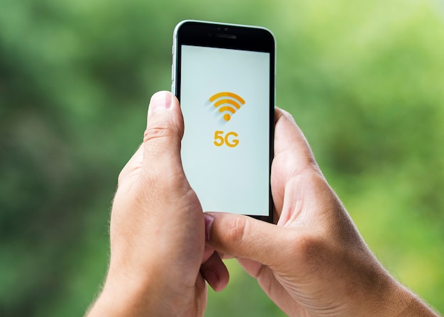 Teléfono con 5 g en pantalla en manos