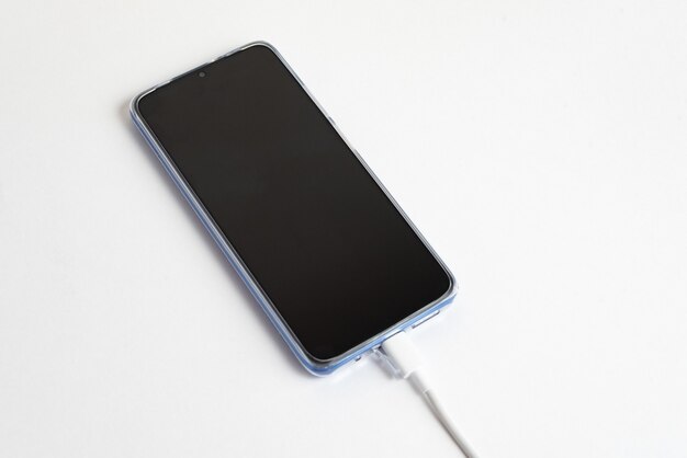 Teléfono celular azul conectado al tipo de cable USB - Cargando