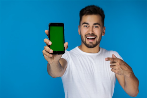 Foto gratuita teléfono celular en primer plano y joven guapo en el fondo