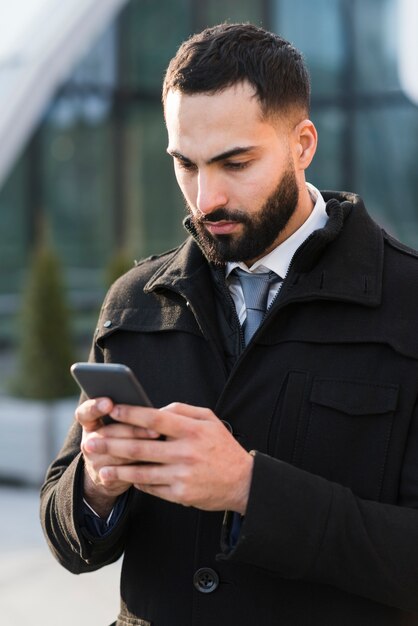 Teléfono de control masculino de negocios de alto ángulo