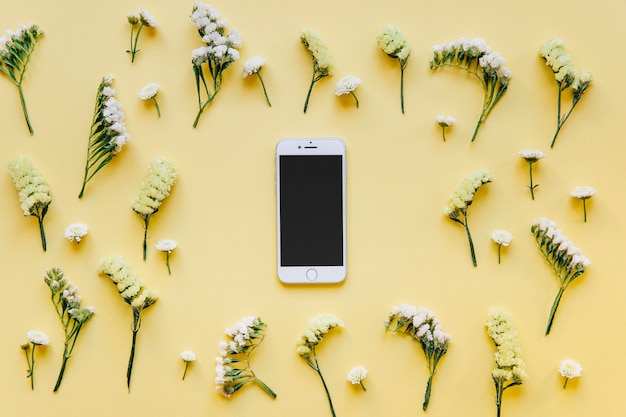 Teléfono inteligente en blanco en flores suaves