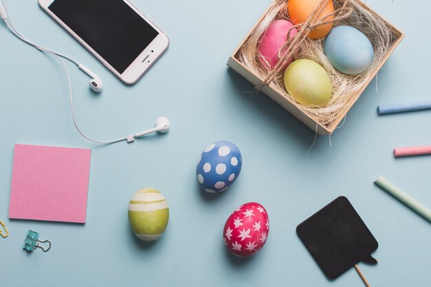 Teléfono inteligente cerca de huevos de colores