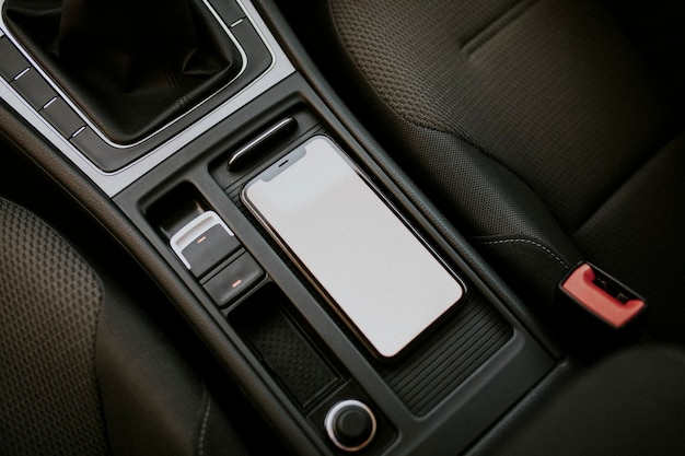 Teléfono móvil de pantalla en blanco dentro de un coche