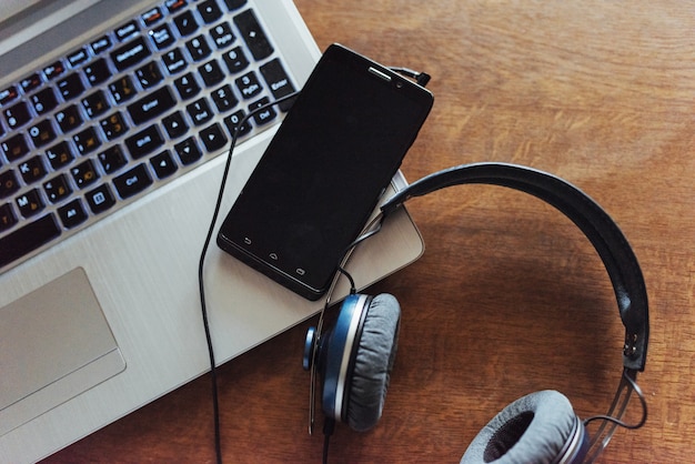 Teléfono portátil y auriculares sobre la mesa.