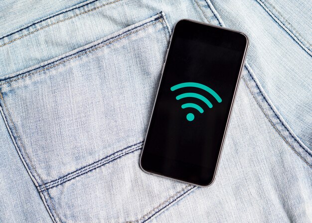 Teléfono con símbolo wifi en la parte superior de los jeans