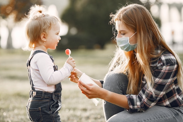 Tema de coronavirus. Familia en un parque de verano. Mujer con camisa de celda.