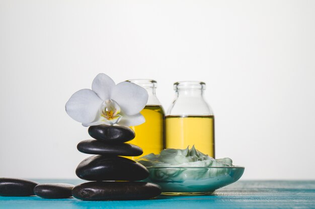 Foto gratuita tema de spa con piedras volcanicas, crema y aceite