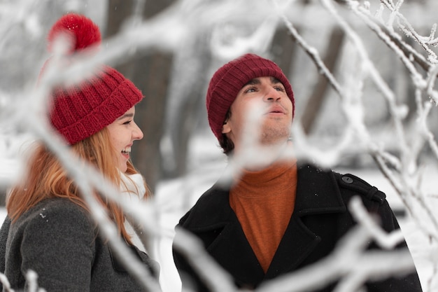 Temporada de invierno cubierto de nieve con pareja tiro medio