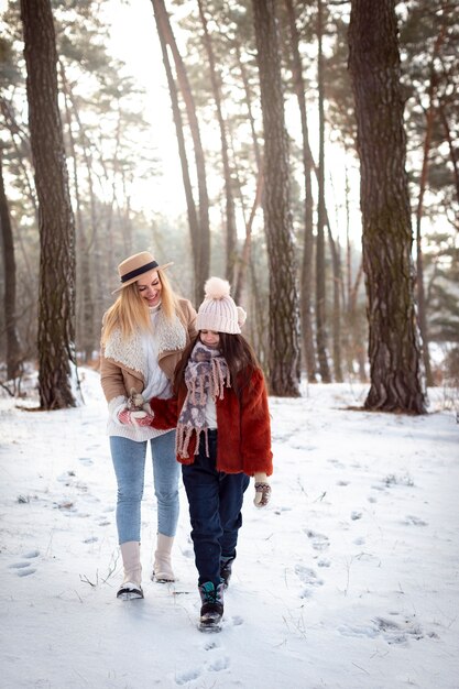 Temporada de invierno de mujer y niña de tiro completo