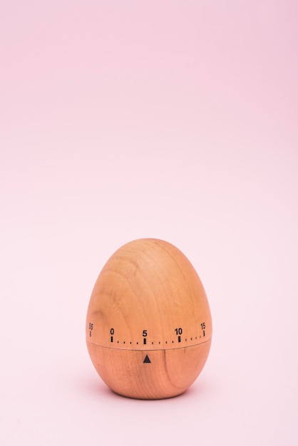 Temporizador de huevo sobre fondo rosa