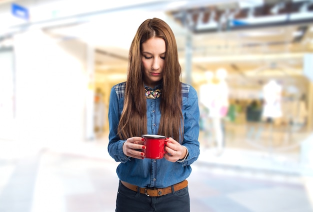 Tendencias mujer joven que mira en una taza roja