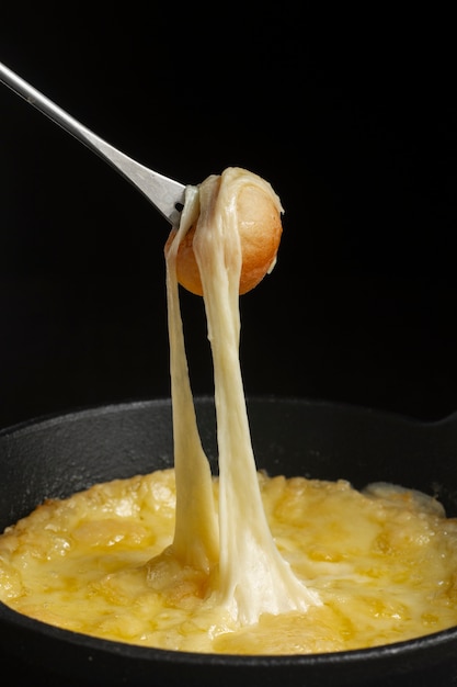 Tenedor con queso derretido y champiñones