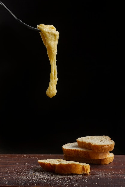 Foto gratuita tenedor con queso derretido y tostadas