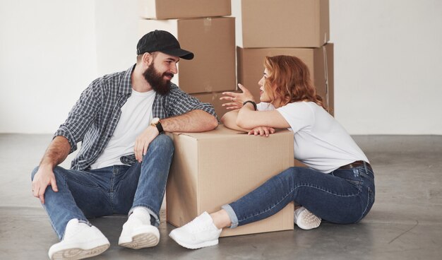 Tener conversación. Pareja feliz juntos en su nueva casa. Concepción de mudanza