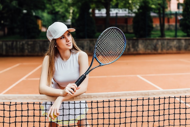 Una tenista joven y bonita seria en la cancha.