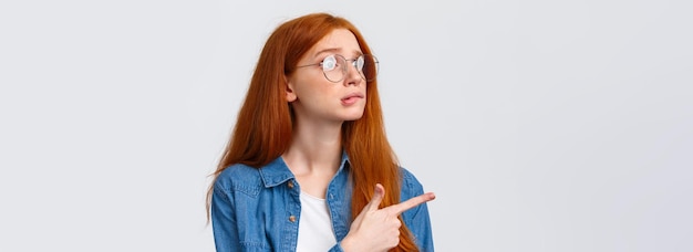 Foto gratuita tentadora linda chica pelirroja viendo algo que quería mordiéndose el labio deseoso y frunciendo el ceño como una compra ansiosa