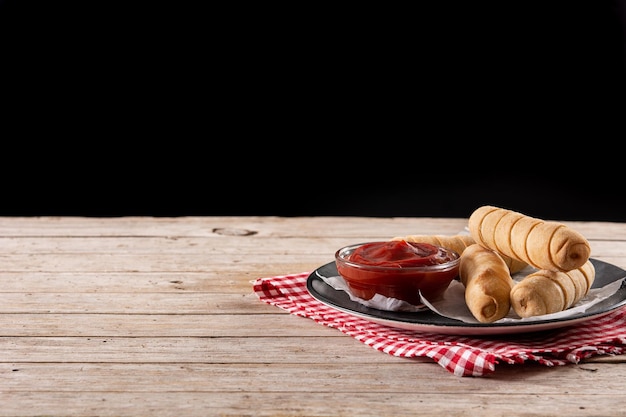 TequeÃ ± os latinoamericanos rellenos de queso sobre mesa de madera