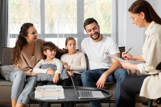 Terapeuta y familia sonriente de cerca