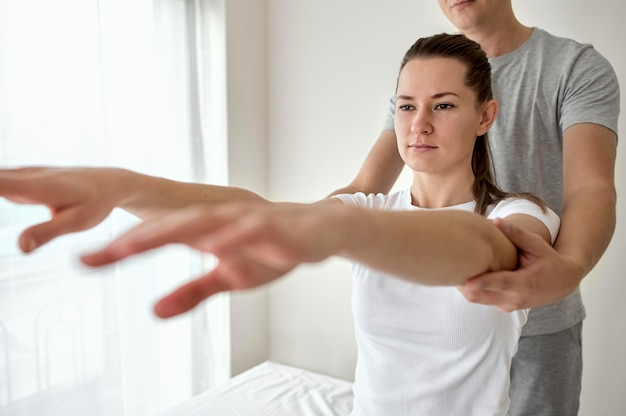 Foto gratuita terapeuta en fisioterapia con paciente