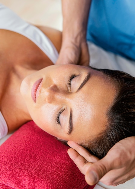 Terapeuta osteopático masculino comprobando la columna del cuello del paciente femenino