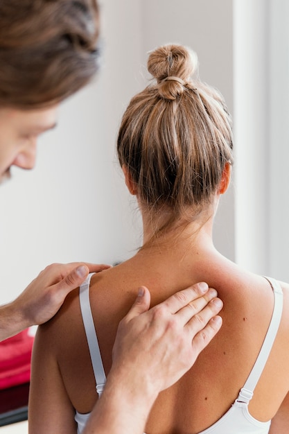 Foto gratuita terapeuta osteopático masculino comprobando la columna vertebral del paciente