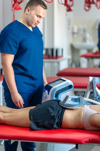 La terapia electromagnética de la espalda el fisioterapeuta médico utiliza equipos médicos