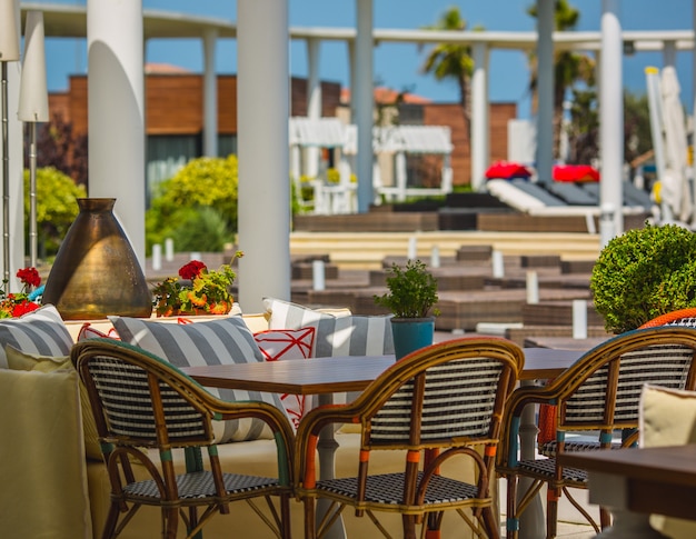 Terraza de un hotel repleto de muebles blandos en un espacio verde.