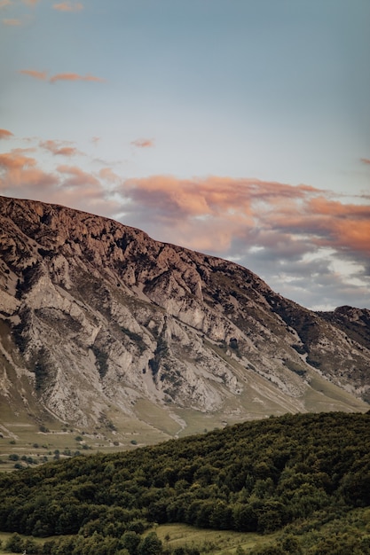 Terreno boscoso verde y pintorescas rocas bajo el cielo nublado, aldea de Rimetea en Rumania