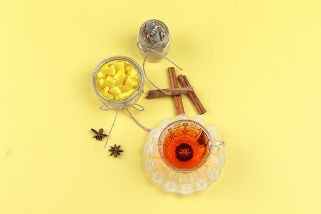 Terrones de azúcar, especias, hierbas secas y té en una taza de vidrio