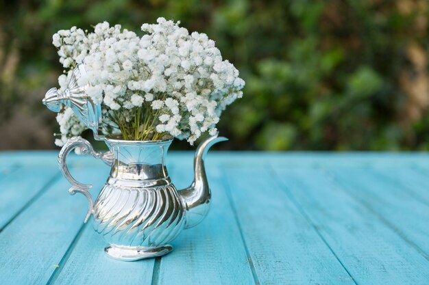 Foto gratuita tetera decorativa llena de flores blancas