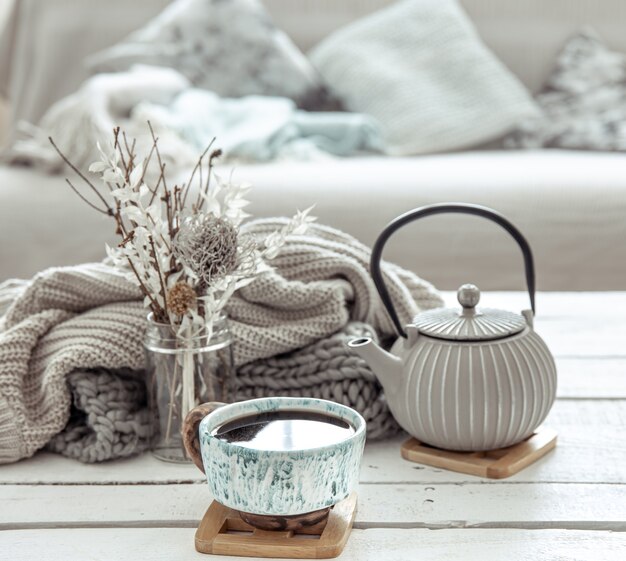 Una tetera y una hermosa taza de cerámica con detalles decorativos en una sala de estar estilo Hygge