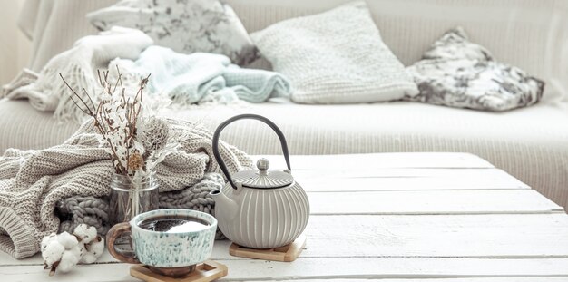 Una tetera y una hermosa taza de cerámica con detalles decorativos en una sala de estar estilo Hygge