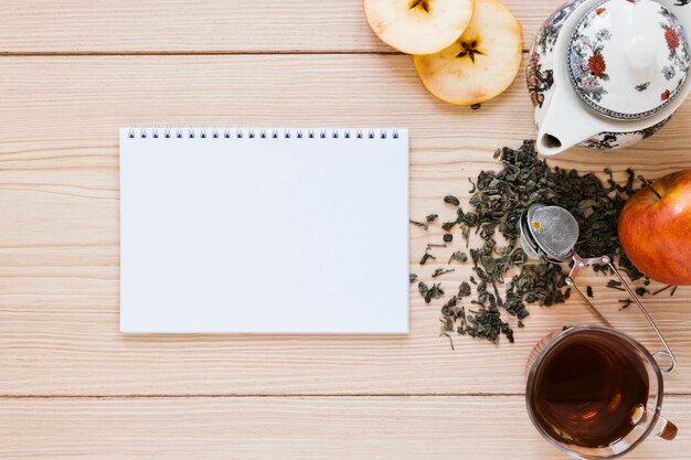 Tetera con manzana y maqueta de cuaderno