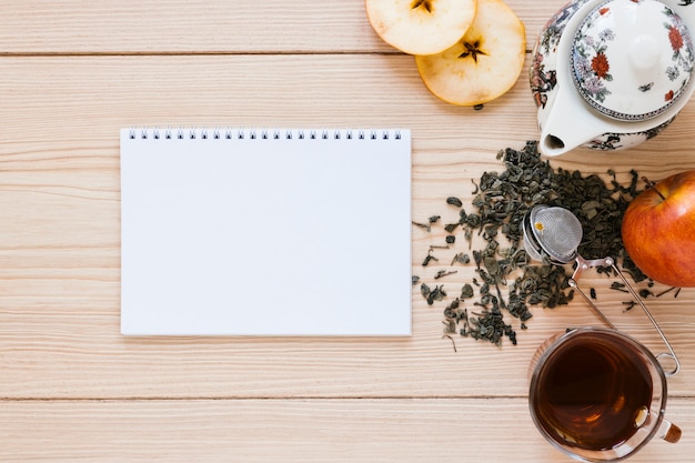 Tetera con manzana y maqueta de cuaderno