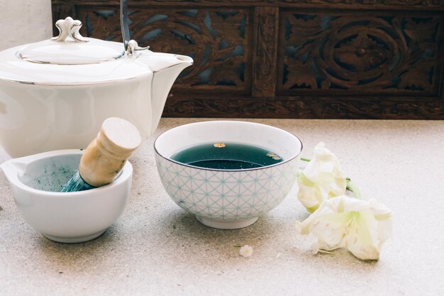 Tetera y taza con té azul