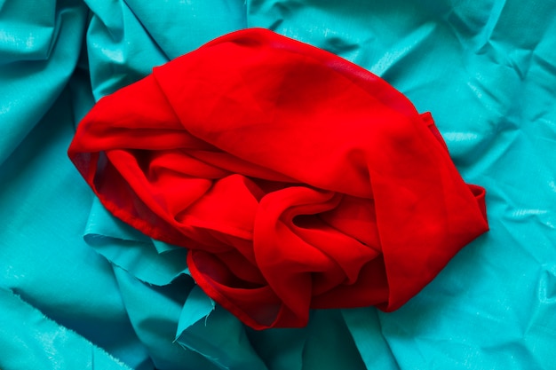 Foto gratuita textil rojo liso sobre fondo de tela turquesa