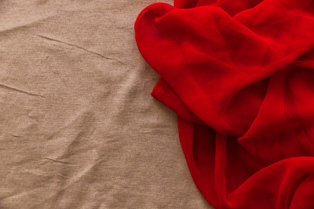 Textil rojo suave sobre fondo de tela marrón