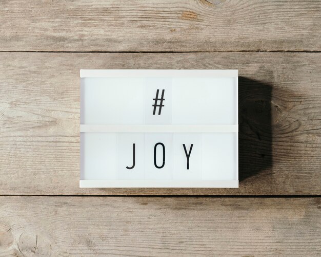 Texto de alegría sobre un panel led y fondo de madera