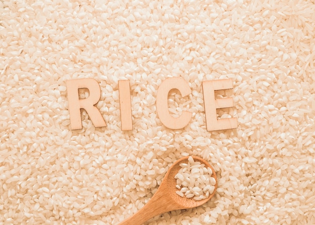 Texto en granos de arroz blanco con cuchara de madera