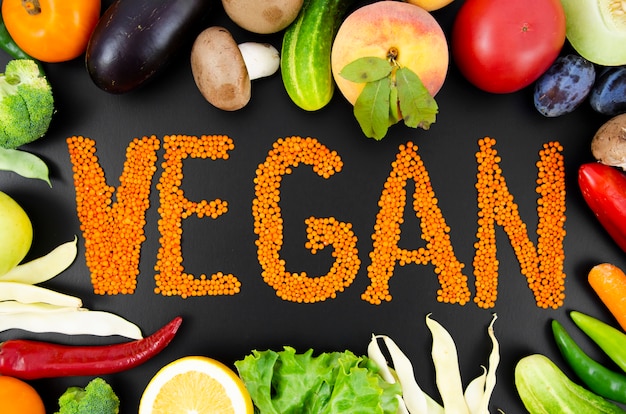 Foto gratuita texto de naranja vegano rodeado de frutas y verduras frescas
