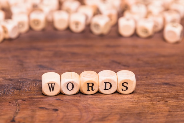 Texto de la palabra en dados de madera sobre el escritorio marrón
