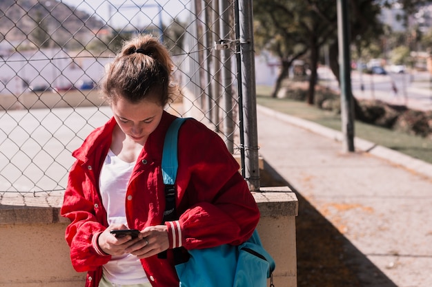 Texto que mecanografía de la chica joven en el smartphone