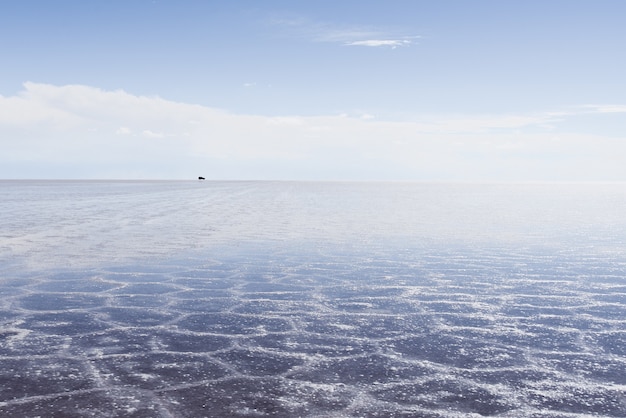 Textura de arena visible bajo el mar cristalino y el cielo