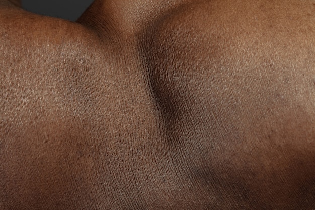 Textura detallada de la piel humana. Primer plano del cuerpo masculino joven afroamericano. Concepto de cuidado de la piel, cuidado corporal, salud, higiene y medicina. Se ve bella y bien cuidada. Dermatología.
