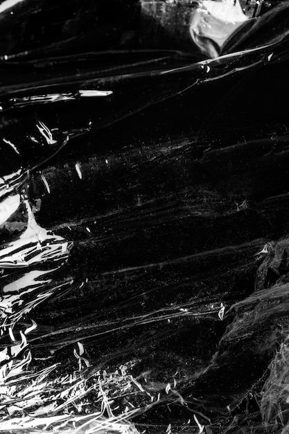 Foto gratuita textura de envoltura de plástico arrugada sobre un fondo negro
