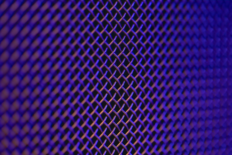 Foto gratuito textura de primer plano de una parrilla de metal de un altavoz de música en iluminación de colores
