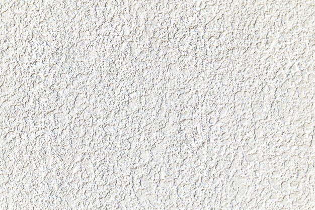 Textura rugosa de la pared enyesada de cemento blanco