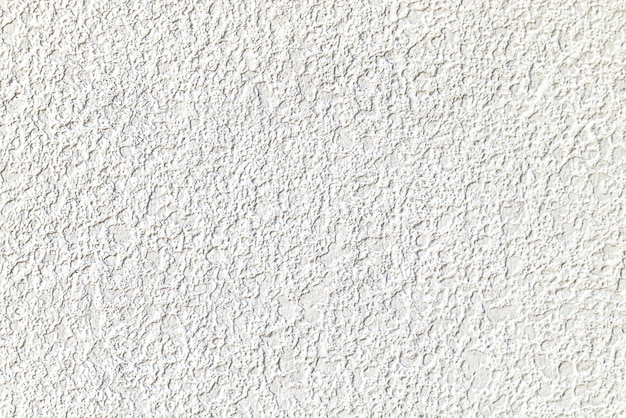Textura rugosa de la pared enyesada de cemento blanco