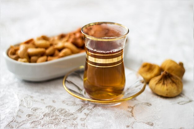 Tiempo de bocadillo con la taza de té, los higos y el anacardo