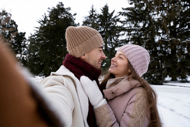 Tiempo de invierno de pareja sonriente de tiro medio